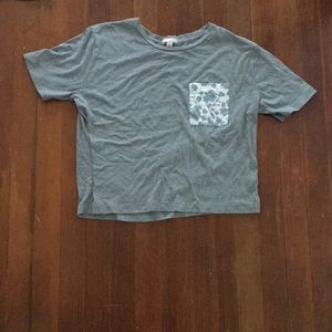 Grey cropped T-shirt with floral pocket design.
